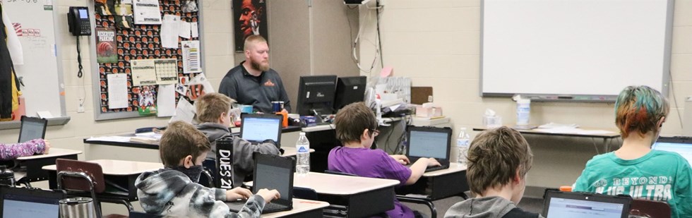 Students and teacher in class on laptops