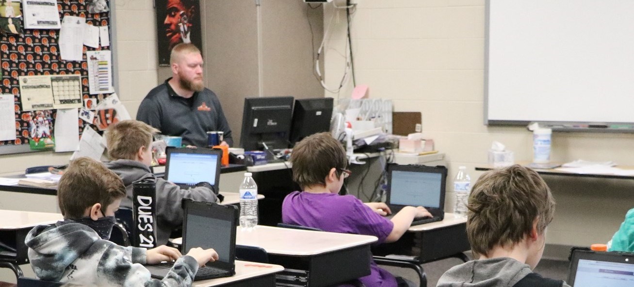 students at desks with laptops